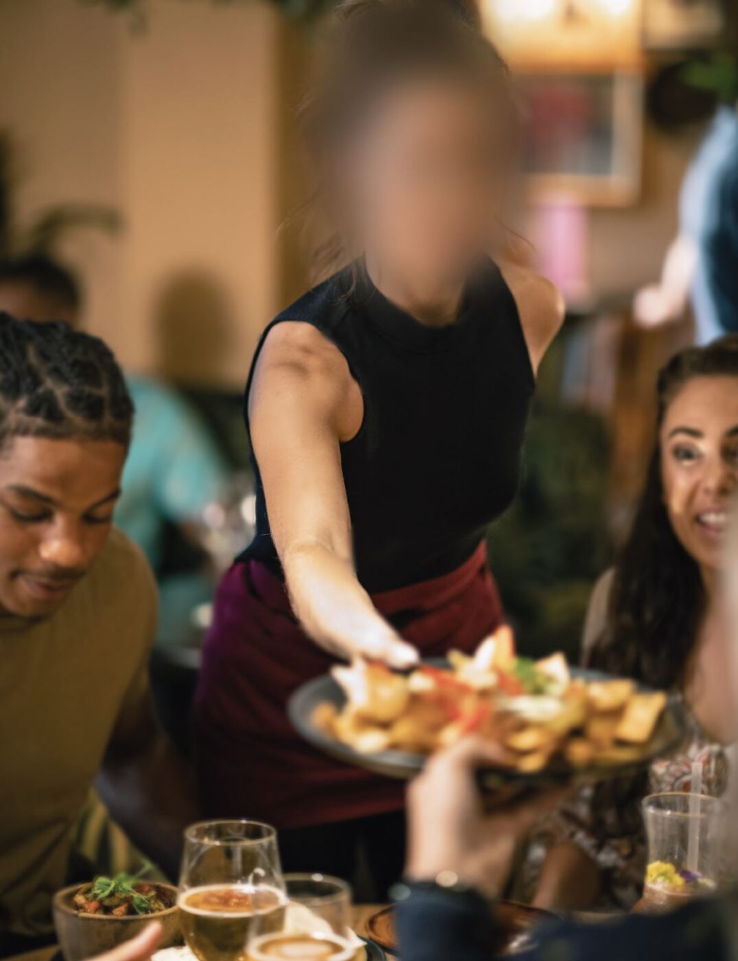 Photographie d’une scène se déroulant dans un restaurant perçue par une personne qui présente une mauvaise acuité visuelle au centre de l’image. Le visage de la serveuse n’est plus reconnaissable.