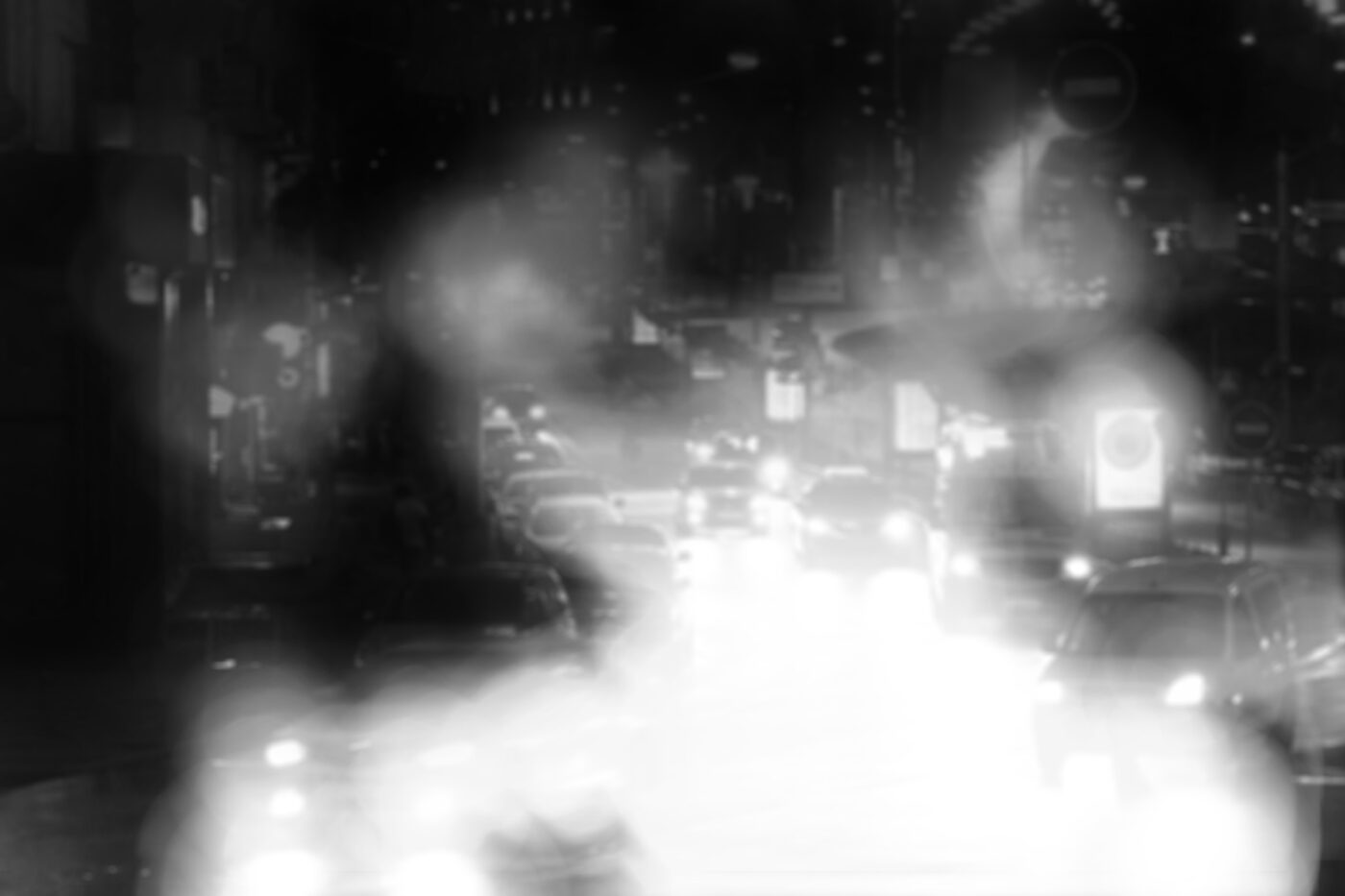 Simulation de l'héméralopie : une route très fréquentée la nuit. Les feux des véhicules et les publicités lumineuses provoquent un fort éblouissement.