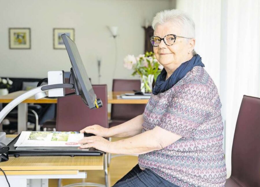 AMD-Patientin sitzt vor Lesegerät