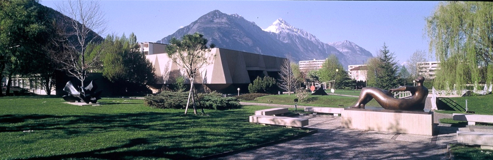 Photo de la Fondation Pierre Gianadda, avec le parc de sculptures au premier plan et les montagnes en arrière-plan.