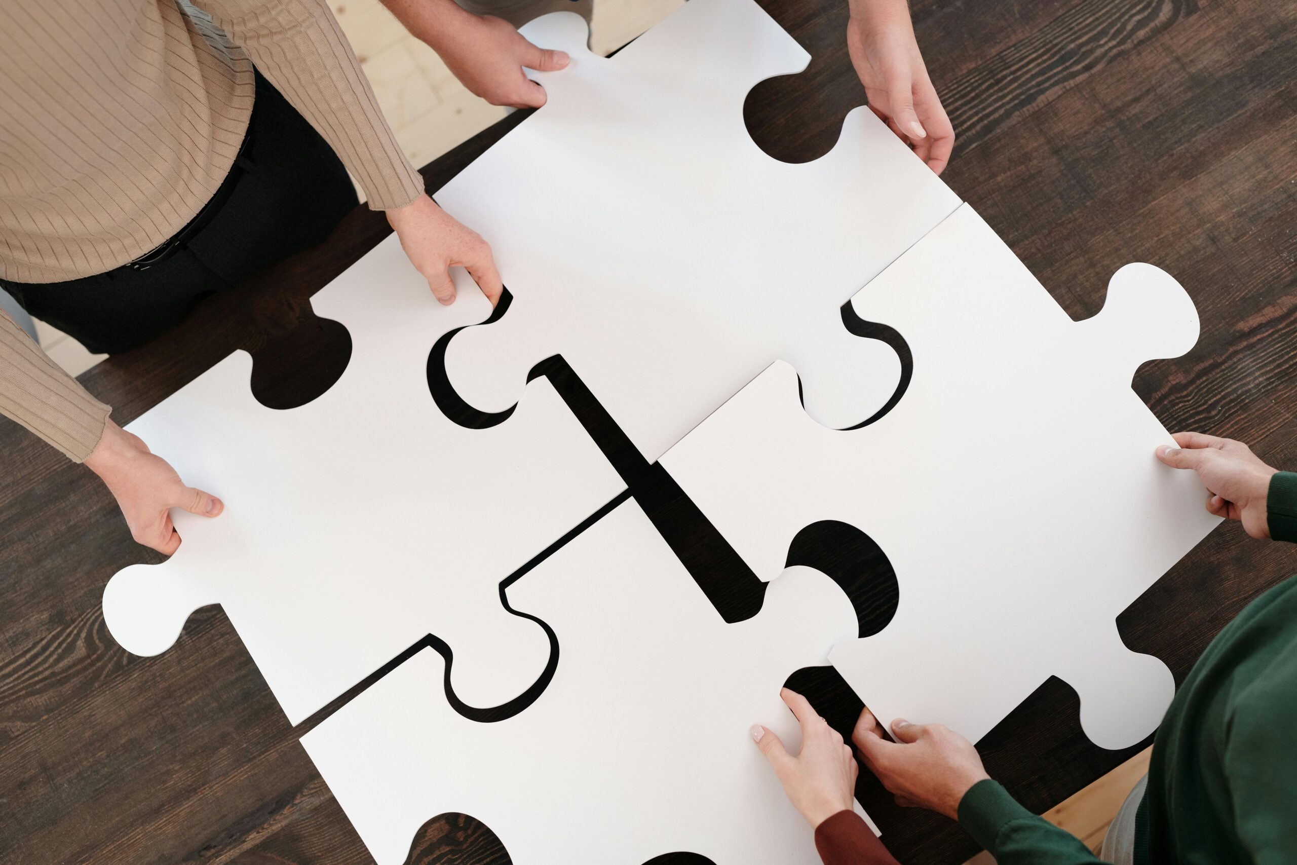 Quatre personnes assemblent quatre pièces de puzzle